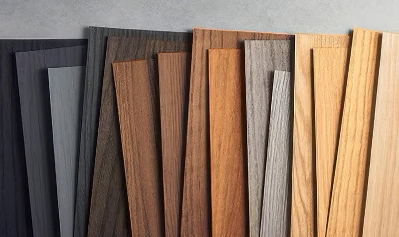 A photo displaying the wood grain film finishes available for Total Security Solutions' steel doors, one of the commercial metal door solutions they offer