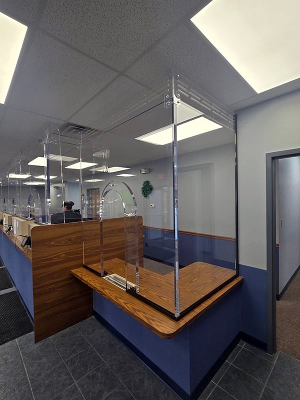 A photo showing bullet proof acrylic glass installed in a financial institution to provide greater protection than conventional glass while providing crystal clear sound quality and visibility