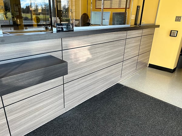 A reception desk in a commercial building that enhances security and provides continued safety for employees through integrated bulletproof protection as a reliable defense