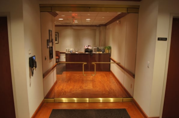 A set of all-glass doors leading to an executive office. 