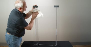 man wiping down clear glass