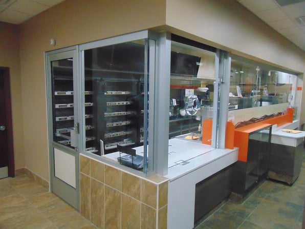 Security windows protect employees behind the counter of a store.