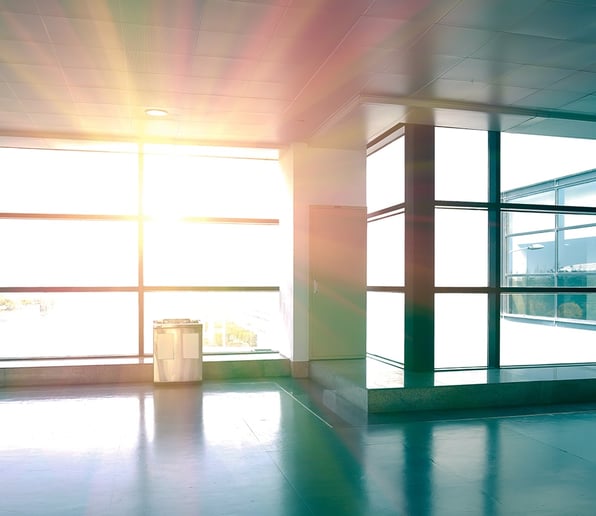 Sunlight streams into a wall of windows, demonstrating the importance of thermally broken frames to prevent ballistic materials from channeling heat or cold into a building.
