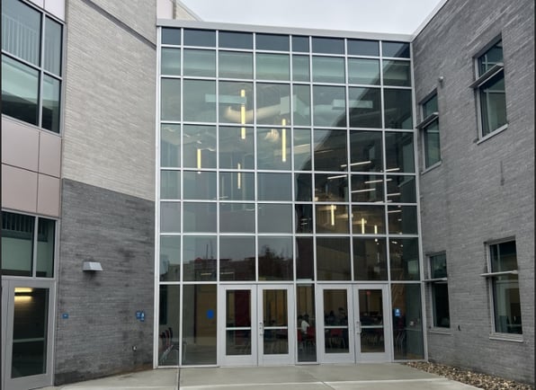 The exterior of a building with window and door glass where security window film is combined with bullet proof glass for a comprehensive security system