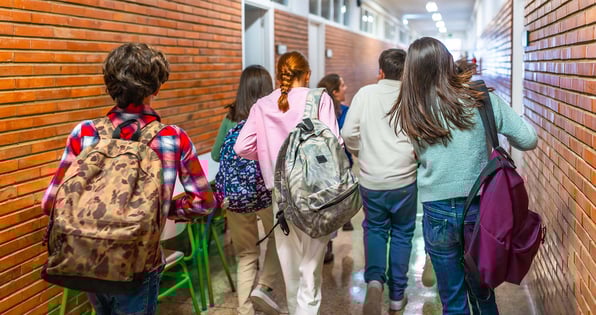 Students walk through a hallway, demonstrating the importance of physical security for schools.